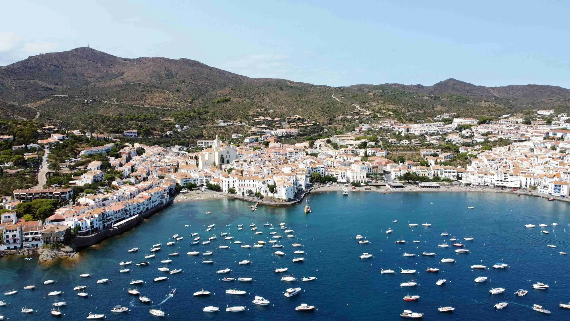 Vista panorámica del pueblo de Cadaqués con casas blancas y el mar Mediterráneo